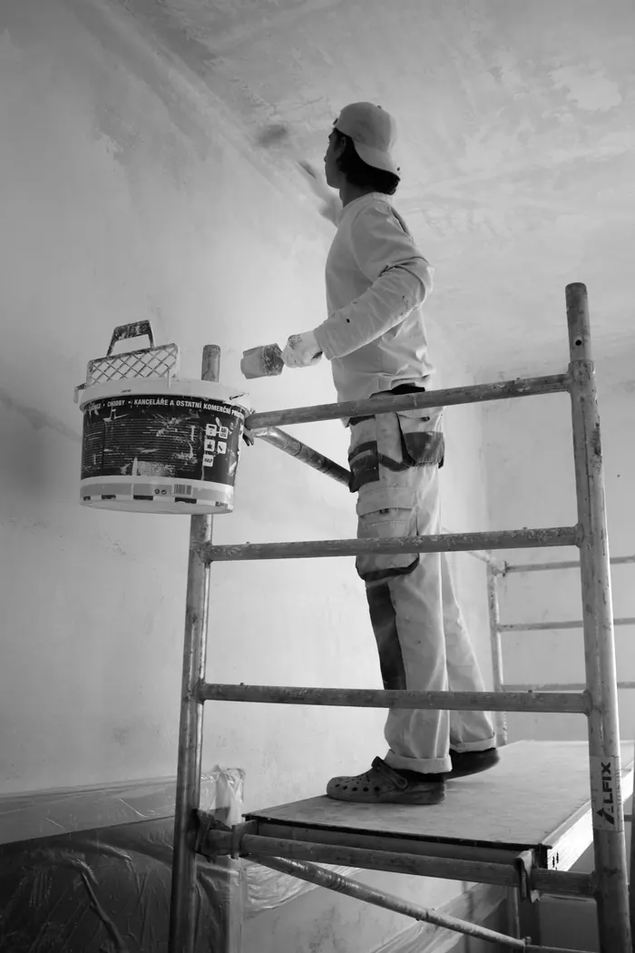Painter rolling warm colour onto interior wall