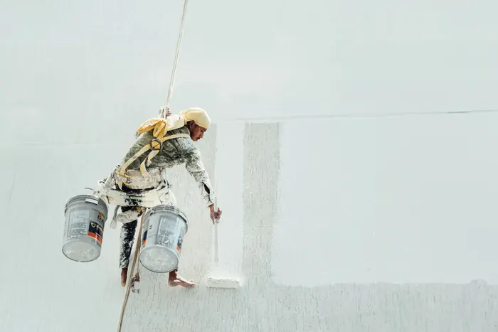 Painter applying crisp white paint to interior wall